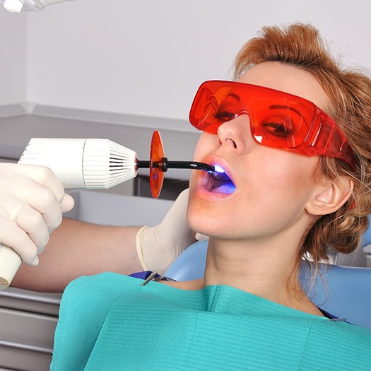 Person getting a curing light shined in their mouth
