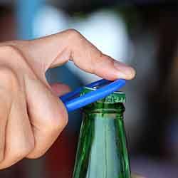 Man opening a bottle with a bottle opener